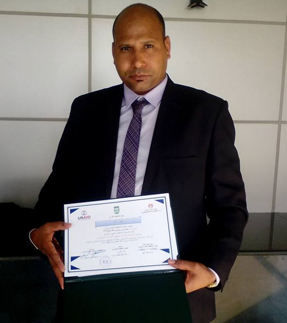 Mr. Haridi displaying a certificate received for completion of a training program in reading financial indicators. 